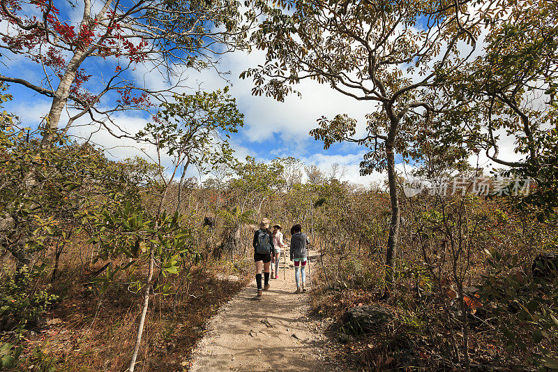 母亲和女儿走在Chapada dos Veadeiros国家公园肮脏的小路上，Goiás，巴西。